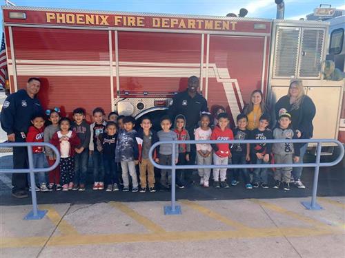 students standing in front of a phoenix fire truck